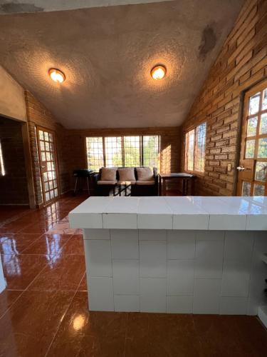 a living room with a large white counter in a room at Cabaña Mi Pequeño Paraíso in Cuernavaca