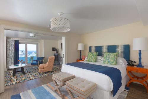 a bedroom with a large bed and a living room at The Break Hotel in Narragansett