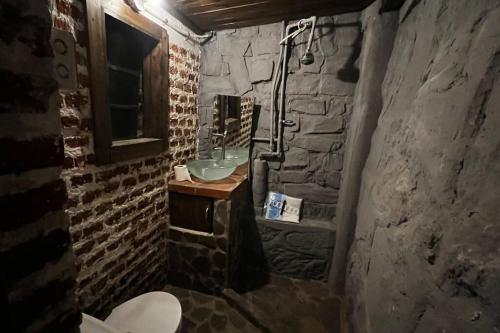 a bathroom with a sink and a stone wall at Casttle Atocha in Amatitlán