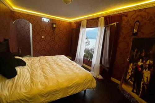 Un dormitorio con una cama grande y una ventana en Casttle Atocha en Amatitlán