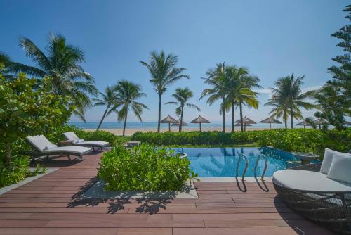 峴港的住宿－Danang Marriott Resort & Spa, Non Nuoc Beach Villas，一个带游泳池和棕榈树的度假村