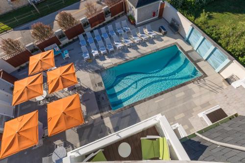 an overhead view of a swimming pool with chairs and umbrellas at The Break Hotel in Narragansett