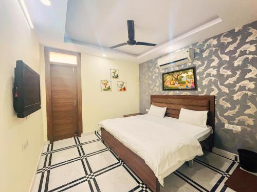 - une chambre avec un lit et une télévision à écran plat dans l'établissement Roomshala 168 Starlight Suites - Near Max Hospital, à New Delhi