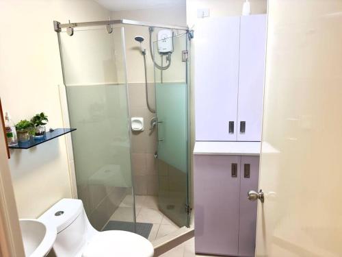 a bathroom with a toilet and a glass shower at Stay comfy & feel Homealike #32 in Iloilo City