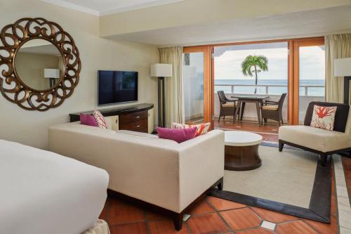 uma sala de estar com um sofá branco e um espelho em The House by Elegant Hotels - All-Inclusive, Adults Only em Saint James