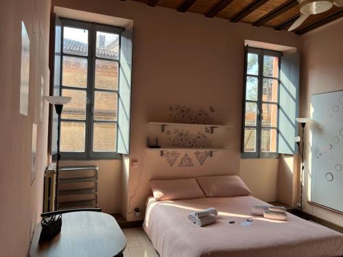 um quarto com uma cama grande e 2 janelas em Minimal Studio con travi a vista em Piacenza