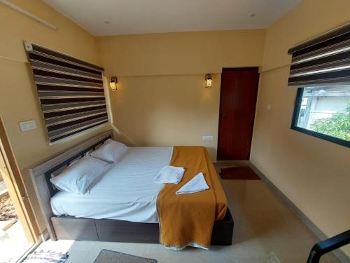 a small bedroom with a bed and a window at Karthika Homes in Anachal