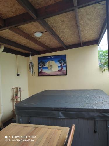 a bed in a room with a table at Les Caze de la Mer Cassée in Saint-Philippe