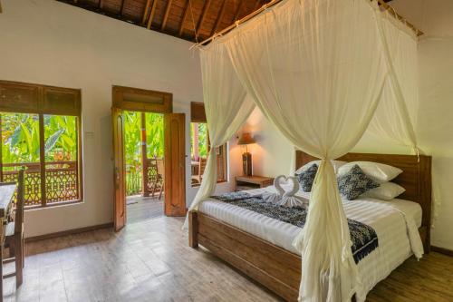 - une chambre avec un lit et une moustiquaire dans l'établissement Abian Ubud View, à Ubud