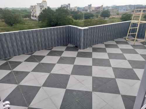 a balcony with a black and white checkered floor at RRRHomestay in Tirupati
