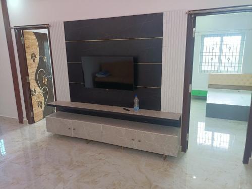 a flat screen tv on a wall in a room at RRRHomestay in Tirupati