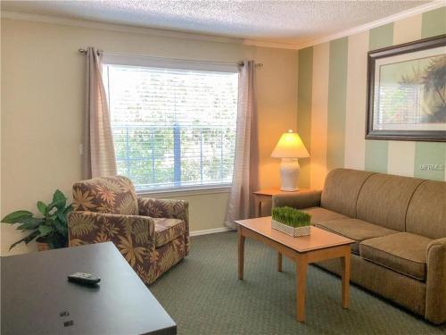 ein Wohnzimmer mit einem Sofa und einem Stuhl in der Unterkunft 1BR Comfort Villa Near Old Town, Disney Universal & Parks in Kissimmee
