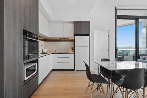 a kitchen and dining room with a table and chairs at Generous 2-Bed Apartment with Great Amenities in Melbourne