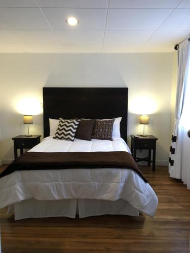 a bedroom with a large bed with two night stands at NASS Bed & Breakfast in Cuenca