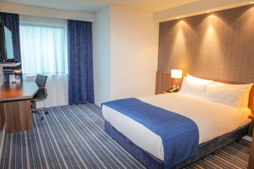 a hotel room with a bed and a desk at Holiday Inn Express London Heathrow T5 by IHG in Slough