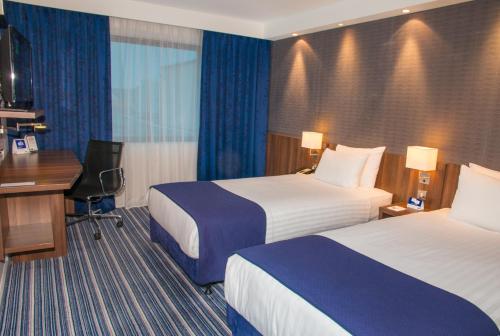 a hotel room with two beds and a desk at Holiday Inn Express London Heathrow T5 by IHG in Slough