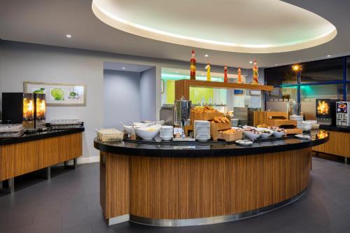 a restaurant with a counter with bowls of food at Holiday Inn Express London Heathrow T5 by IHG in Slough