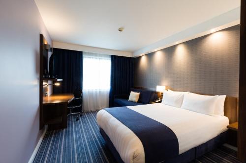 a hotel room with a bed and a desk at Holiday Inn Express London Heathrow T5 by IHG in Slough