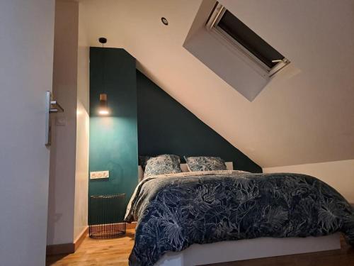 a bedroom with a bed with a green accent wall at T2 / 24h du Mans / Circuit / Karting / Antares / Boulerie Jump / Stade de foot in Le Mans