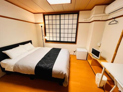 a bedroom with a large bed and a window at IKI Island HUB in Iki