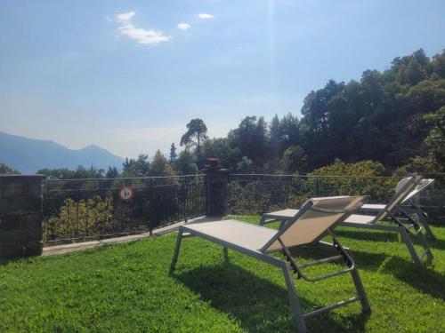 two chairs and a table in the grass at Casa Moorea - b44923 in Brione sopra Minusio