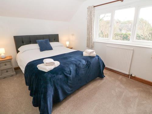 a bedroom with a large bed with towels on it at Cherry Tree Cottage in Ashbourne