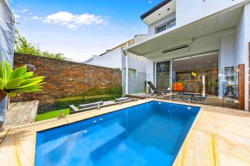 a swimming pool in front of a house at Convenient 4BR with Private Pool close to Airport in Sydney