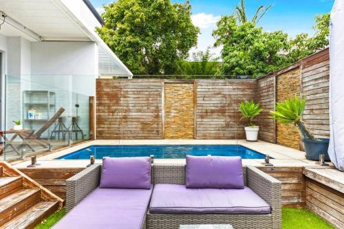 a patio with purple cushions and a swimming pool at Convenient 4BR with Private Pool close to Airport in Sydney