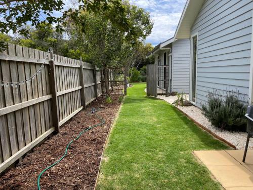 a yard with a fence next to a house at Marittimo in Point Lonsdale