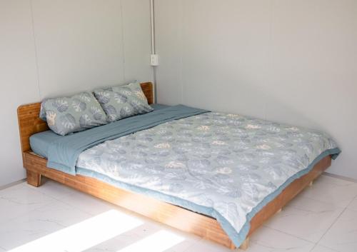 a bedroom with a bed with a blue comforter and pillows at Nguyễn Lagi Homestay in La Gi