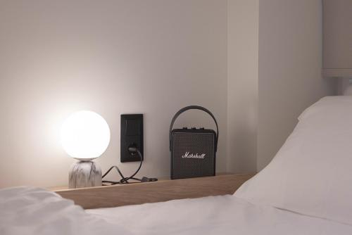 a bedroom with a bed and a lamp and a speaker at Urban Folks Svolou in Thessaloniki