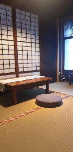 une chambre avec un banc, un tapis et une fenêtre dans l'établissement Johns House じょんのやど, à Himeji