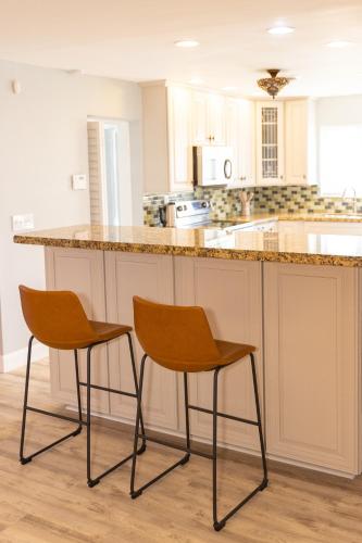 a kitchen with two chairs at a counter at Private Villa with Pool and Sauna in Dania Beach