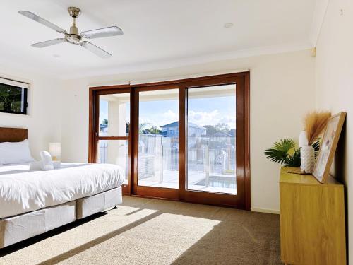 a bedroom with a bed and a sliding glass door at Waterfront Haven Balinese Villa at Bundall in Gold Coast