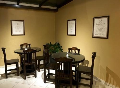 two tables and chairs in a room with yellow walls at NASS Bed & Breakfast in Cuenca