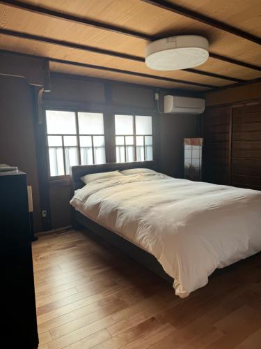 - un grand lit dans une chambre aux murs bleus dans l'établissement Johns House じょんのやど, à Himeji