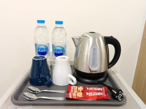 a tray with a coffee maker and bottles of water at Beyond 21 Hotel in Khon Kaen