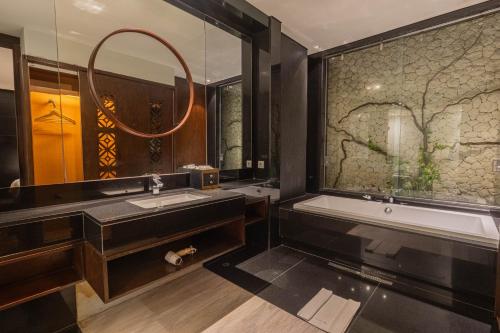 a bathroom with two sinks and a tub and a mirror at The Sterling Villas in Uluwatu