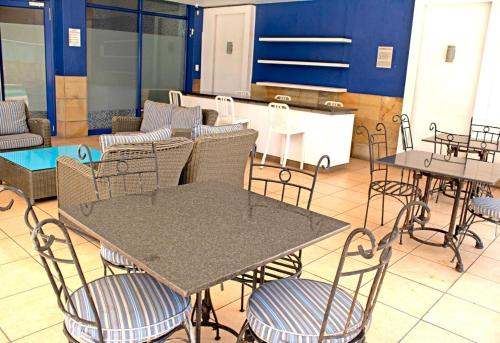 een restaurant met tafels en stoelen en een keuken bij Unit 57 Oceanic Hotel in Durban