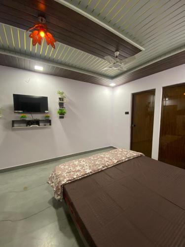 a bedroom with a bed and a flat screen tv at Rock n Ocean2 , Beach stay in Udupi