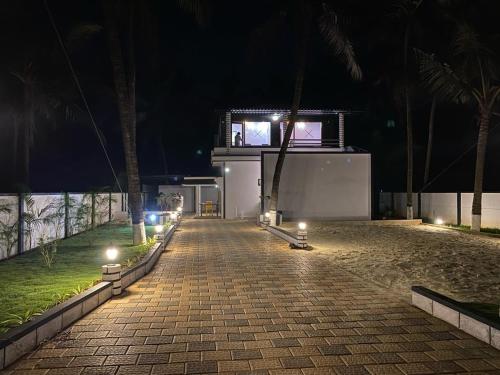 a brick walkway with lights on it at night at Rock n Ocean2 , Beach stay in Udupi