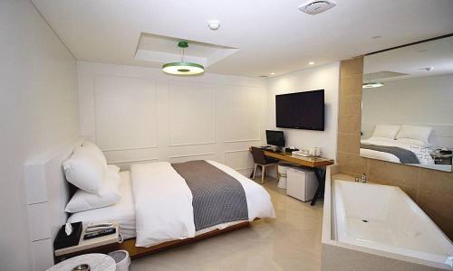 a bedroom with a bed and a desk and a television at Hapjeong Circle Hotel in Seoul