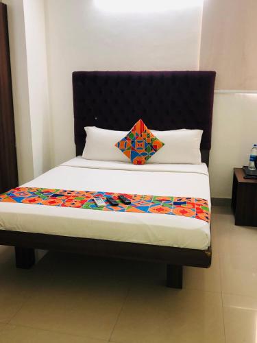 a bed with a black headboard and a colorful blanket at Astra Hotels & Suites - HSR Layout Sector 1, Near Ecospace Bellandur in Bengaluru
