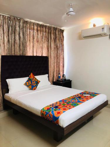 a bedroom with a large bed with a colorful blanket at Astra Hotels & Suites - HSR Layout Sector 1, Near Ecospace Bellandur in Bengaluru