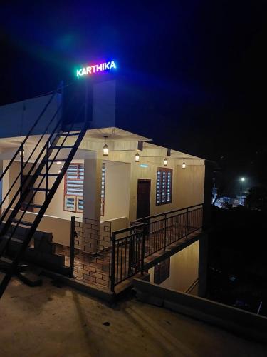 a neon sign on the side of a building at night at Karthika Homes in Anachal