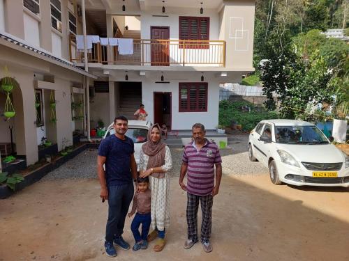 a group of people standing in front of a house at Karthika Homes in Anachal