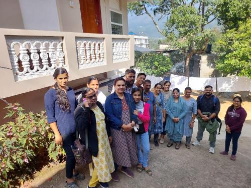 a group of people standing in front of a building at Karthika Homes in Anachal