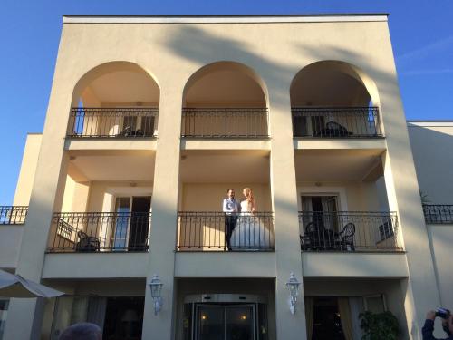 two people standing on the balconies of a building at Hotel Holiday Sul Lago in Bolsena