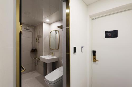 La salle de bains est pourvue de toilettes et d'un lavabo. dans l'établissement Hotel The One, à Gangneung