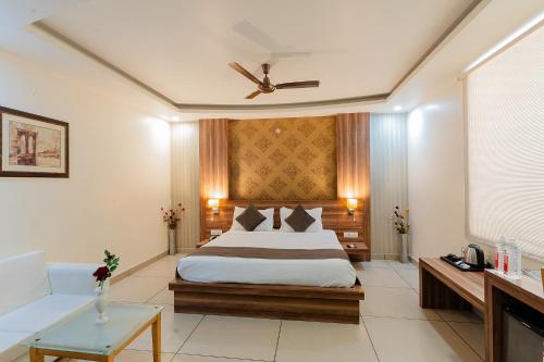 um quarto de hotel com uma cama e um sofá em FabHotel Signature Inn em Jaipur